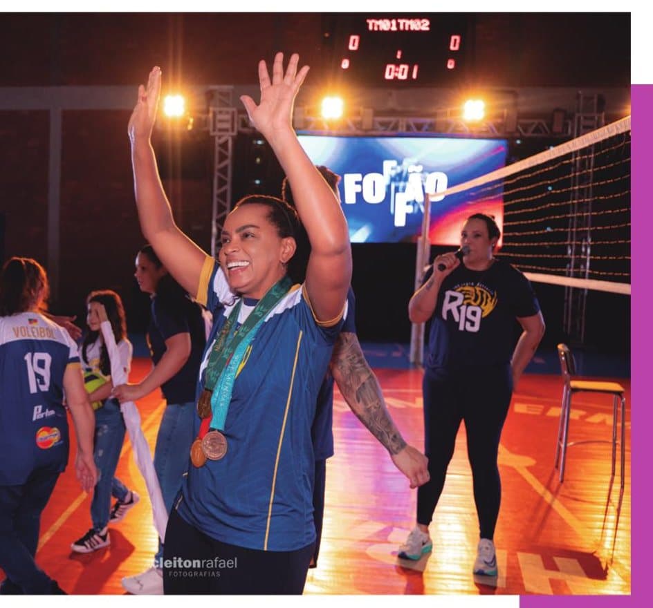 Fofão, de braços erguidos e com as medalhas no peito, em quadra durante o evento de 1 ano